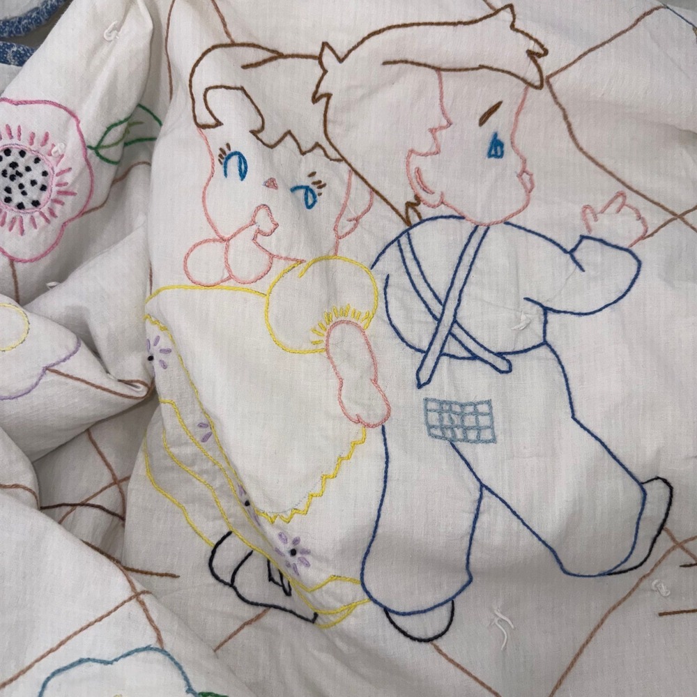 Vintage baby quilt featuring embroidered figures and floral motifs 35.75"x56"‎